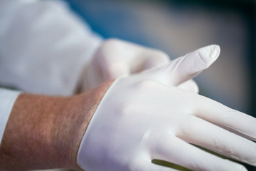 Fototapeta na wymiar Arzt zieht Handschuhe an-Coronakrise, Quarantäne,Krankenhaus, Schutzkleidung