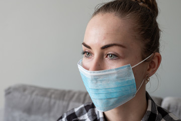 Girl with medical mask to protect her from virus. Coronavirus pandemic. Woman with mask standing . People being hospitalized, diagnosed, often put in carantine (isolation) to stop spreading Corona.