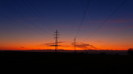 Fototapeta na wymiar High voltage poles standing on the background of the blue hour