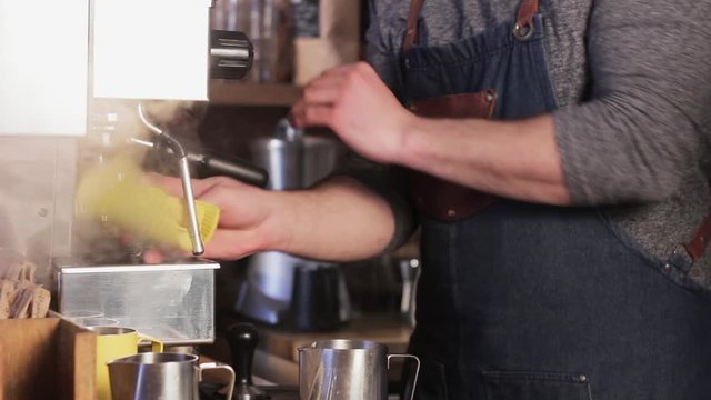 Italian coffee machine. Professional barista making cappuccino. Barista pouring whipped milk in a metal cup.