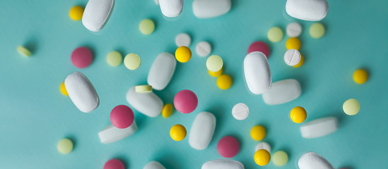 Pills for levitation. Pills on a blue background that fall down. Tablets. Medicine and health. Different types of pills, banner