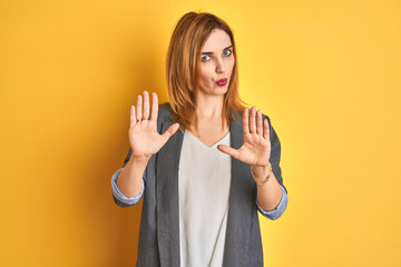 Redhead caucasian business woman over yellow isolated background disgusted expression, displeased...
