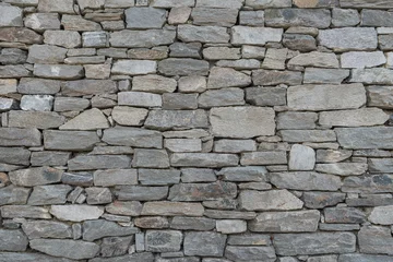 Foto op Aluminium Stone wall texture background - grey stone siding with different sized stones  © emotionpicture
