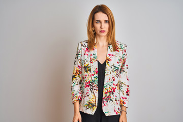 Young caucasian business woman wearing spring floral jacket suit over isolated background skeptic...