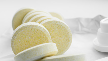 Heap of soluble effervescent vitamin tablets on a paper background. Vitamins and nutritional supplements. Health care and medical. Front view.