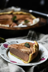 Desserts and bakery products. Piece of ñhocolate shortbread pie with baked pear and cinnamon on a plate. Background image, copy space