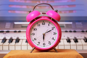 Alarm clock on piano background. Music lesson_