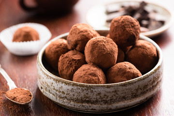 Homemade dark chocolate truffles on wooden background. Closeup view of chocolate candy truffle - 332222180
