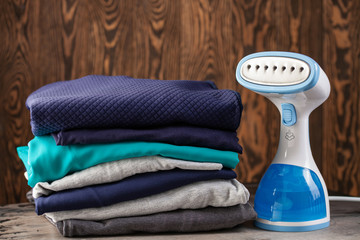 Portable home and travel garment steamer for clothes. Clothes pile. Housework