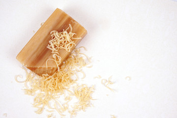 Universal antibacterial natural laundry soap. Brown bar of natural soap Isolated on a white background. Grated to dissolve in water