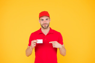 Discount card. Business contact. Delivered to your destination. Service delivery. Courier and delivery. Postman delivery worker. Man red cap yellow background. Delivering purchase. Happy to serve