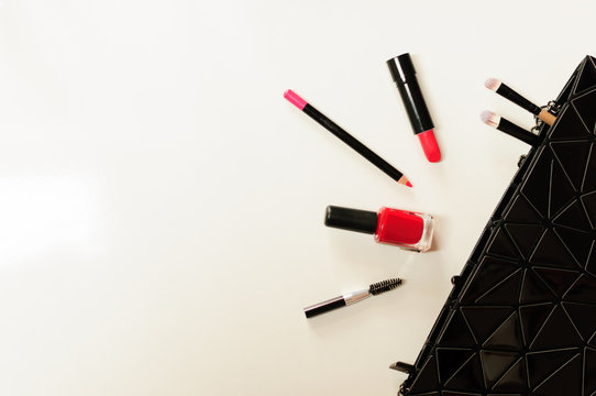 Make up cosmetic bag with professional accessories. Lipsticks and brushes in a black cosmetic bag in white background