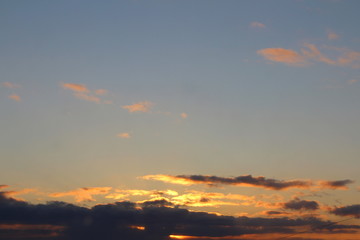 Obraz premium Clouds in the blue sky at sunset or dawn backlit by the sun. Place for text and design