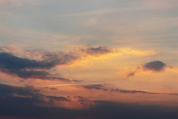 Fototapeta na wymiar Dark clouds are illuminated by the orange light of the evening sun.
