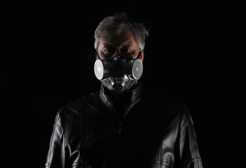 portrait of a man in a black leather jacket and a gas mask