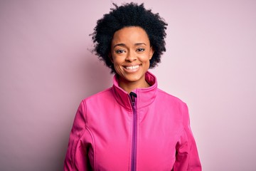 Obraz na płótnie Canvas Young African American afro sportswoman with curly hair wearing sportswear doin sport with a happy and cool smile on face. Lucky person.