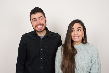 Oops! Portrait of female with specific appearance clenches teeth and looks confusedly aside, realises her bad mistake, poses against copy area for your advertising or promotional background.