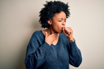 Young beautiful African American afro woman with curly hair wearing casual sweater feeling unwell and coughing as symptom for cold or bronchitis. Health care concept.