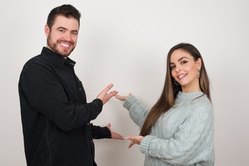 Young beautiful caucasian couple over isolated background Inviting to enter smiling natural with open hands. Welcome sign.