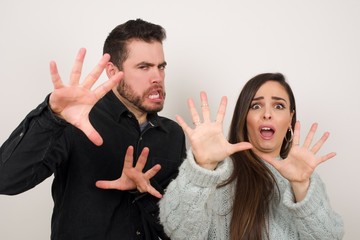 Dissatisfied female model frowns face, has disgusting expression, shows tongue, expresses non...