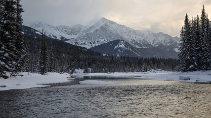 Bow River at sunrise with mountain in background in Banff National Park