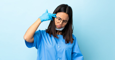 Surgeon woman over isolated blue background with problems making suicide gesture