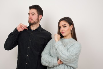 Closeup of cheerful beautiful European young couple look joyful, satisfied and confident, points at themselves with thumb, isolated over studio background.