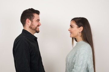 Profile of smiling couple with healthy pure skin smiling to each other. Couple goals