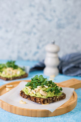 Vegan green toast with avocado paste , nuts and microgreens