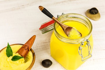 Ghee or clarified butter in jar. Healthy eating and using organic fresh made products. Healthy ingredient for cooking organic meal.Spoon with ghee butter