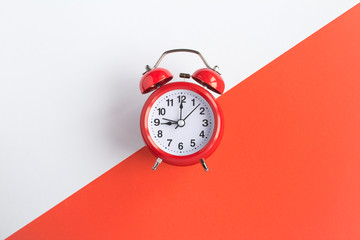 Red alarm clock on the bicolor background.  Top view. Copy space. Closeup. - obrazy, fototapety, plakaty