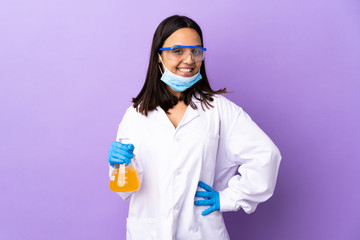 Scientist woman investigating a vaccine to cure coronavirus disease posing with arms at hip and...