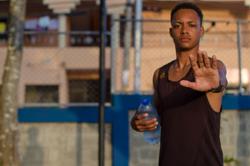 Latino boy model in day sports session making stop gesture