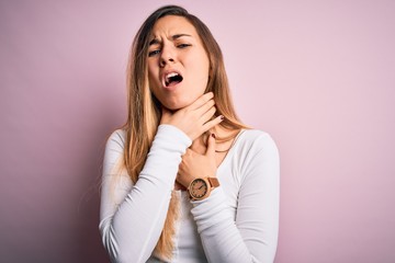 Fototapeta premium Young beautiful blonde woman with blue eyes wearing white t-shirt over pink background shouting suffocate because painful strangle. Health problem. Asphyxiate and suicide concept.