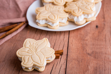 Shortbread cookies with meringue in the form of a flower, on a light wood background.