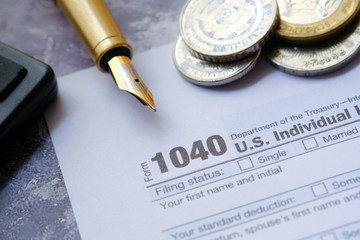 1040 tax form, instructions, pen and calculator.