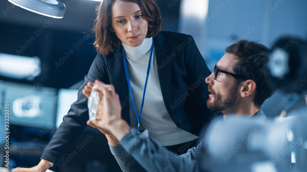Aufkleber futuristic machine engine development engineer working on computer at his desk, talks with female pr