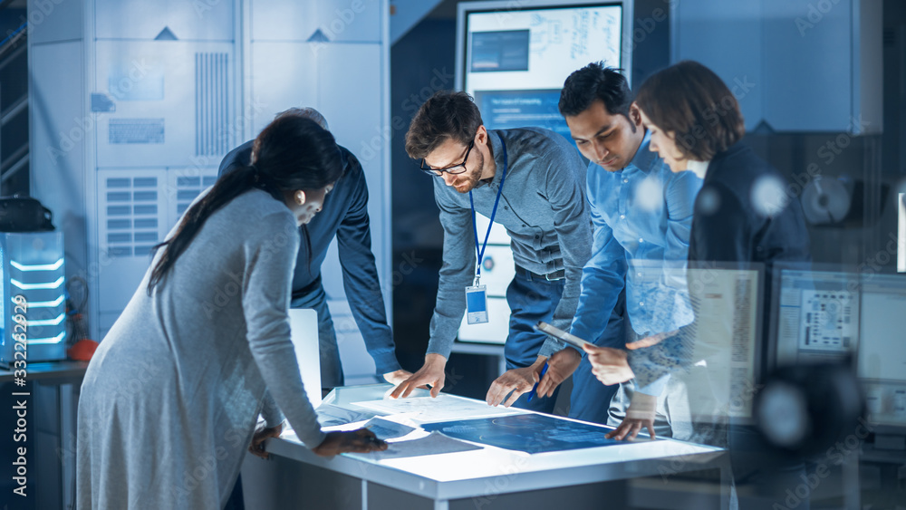 Poster Engineers Meeting in Technology Research Laboratory: Engineers, Scientists and Developers Gathered Around Illuminated Conference Table, Talking and Finding Solution. Industrial Design Facility