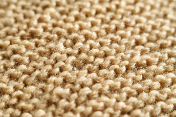 Knitted texture in beige macro with a partially blurred shawl technique