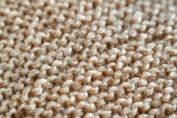 Knitted texture in beige macro with a partially blurred shawl technique