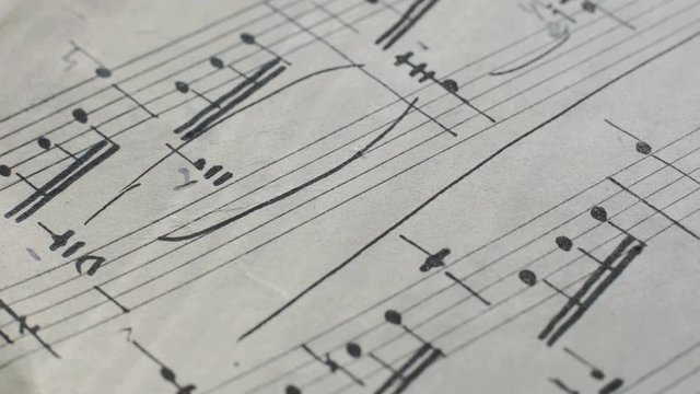 camera movement along a musical notepad, close up, macro view, slider moving