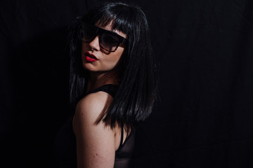woman posing  with glasses on black background