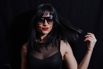 Fototapeta na wymiar woman posing laughing with glasses on black background