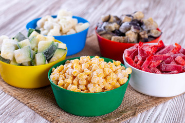 Various frozen vegetables on plastic plates