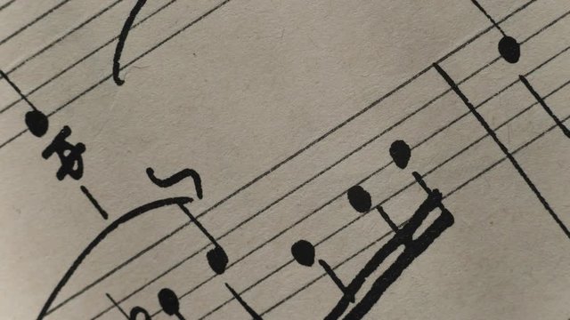 camera movement along a musical notepad, close up, macro view, slider moving