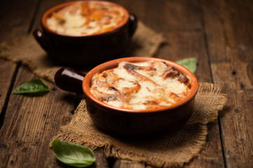Lasagna dish on a rustic table. Food, mozzarella.