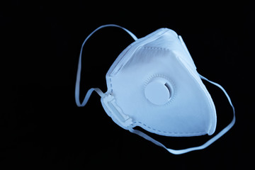 White ffp3 face mask with a valve on a black background