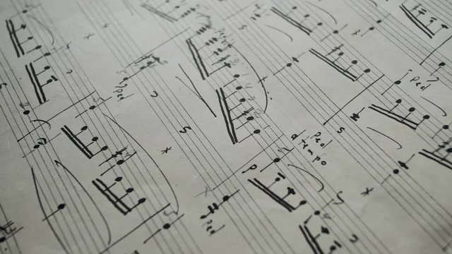 camera movement along a musical notepad, close up, macro view, slider moving