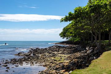 Fototapeta na wymiar Mar, rochas e céu azul da Ilha do Pirata na Praia tropical de Ilhota em Itapema, Santa Catarina
