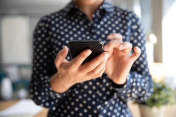 Close up Indian young woman holding smartphone, browsing mobile device apps, playing game, female...